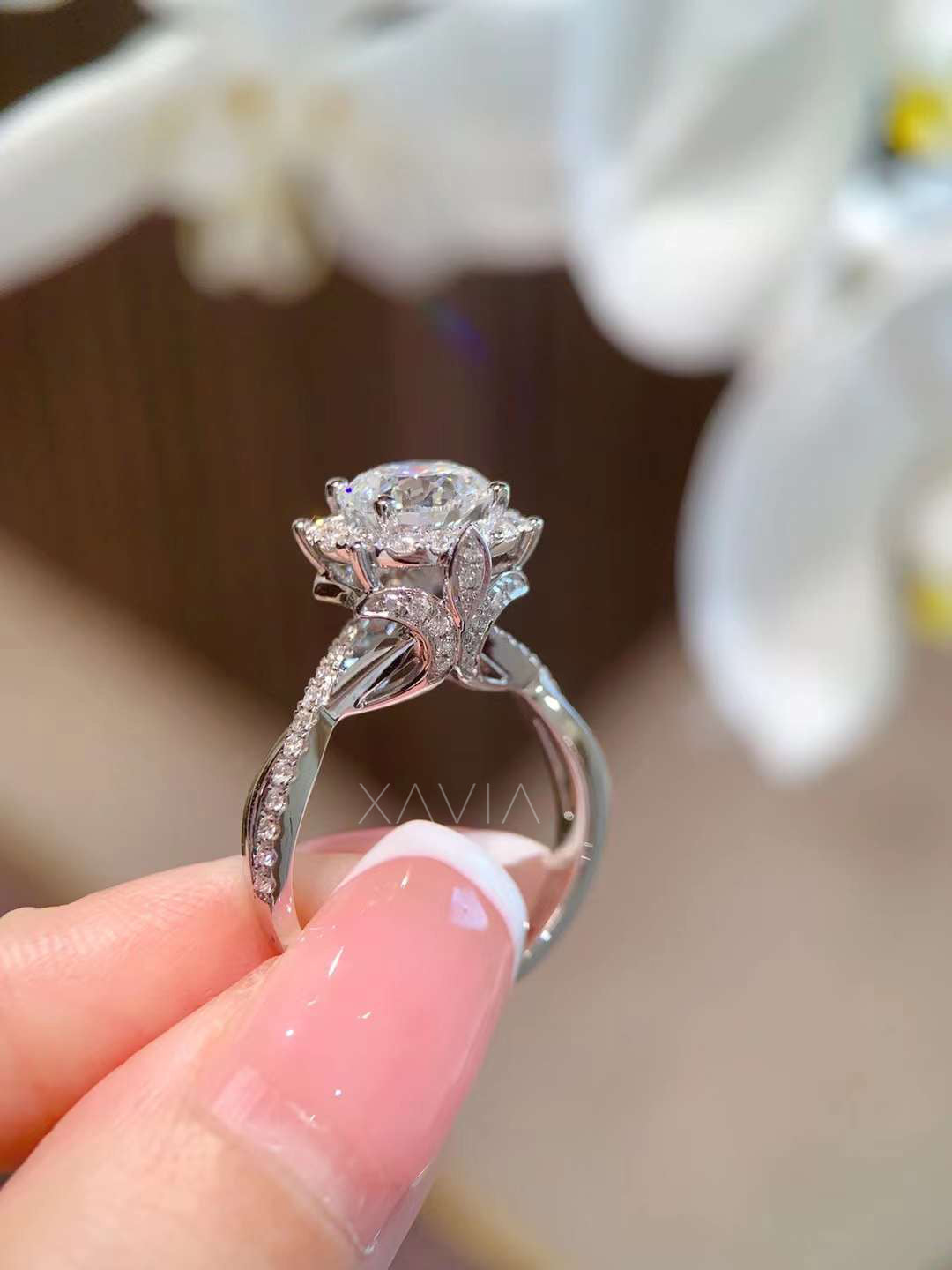 Close-up of round cut halo engagement ring with twisted pavé band and floral gallery, highlighting sparkle and craftsmanship of white gold