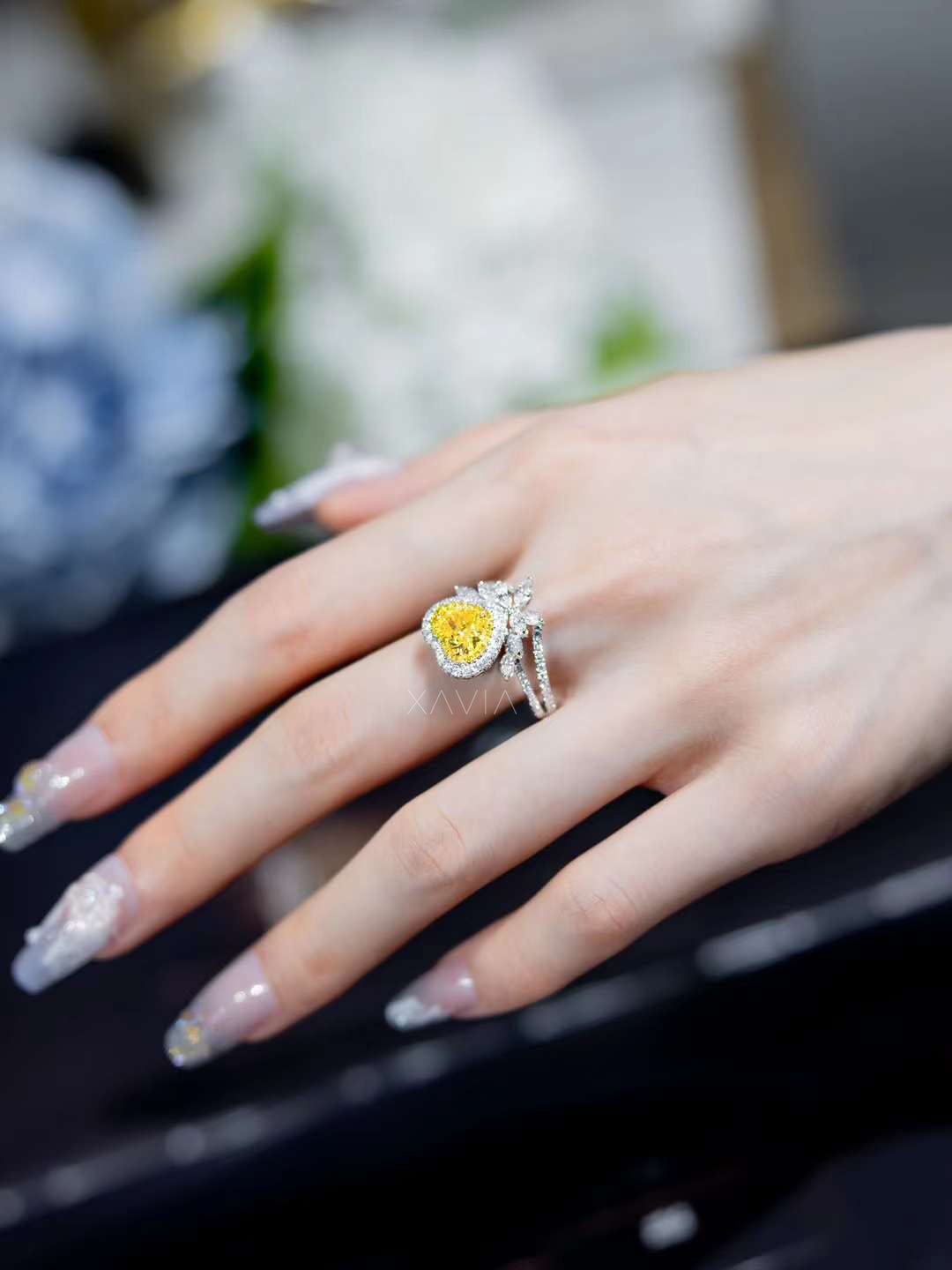 top view of luxury yellow heart diamond ring framed with double halo and white diamond floral petal accents