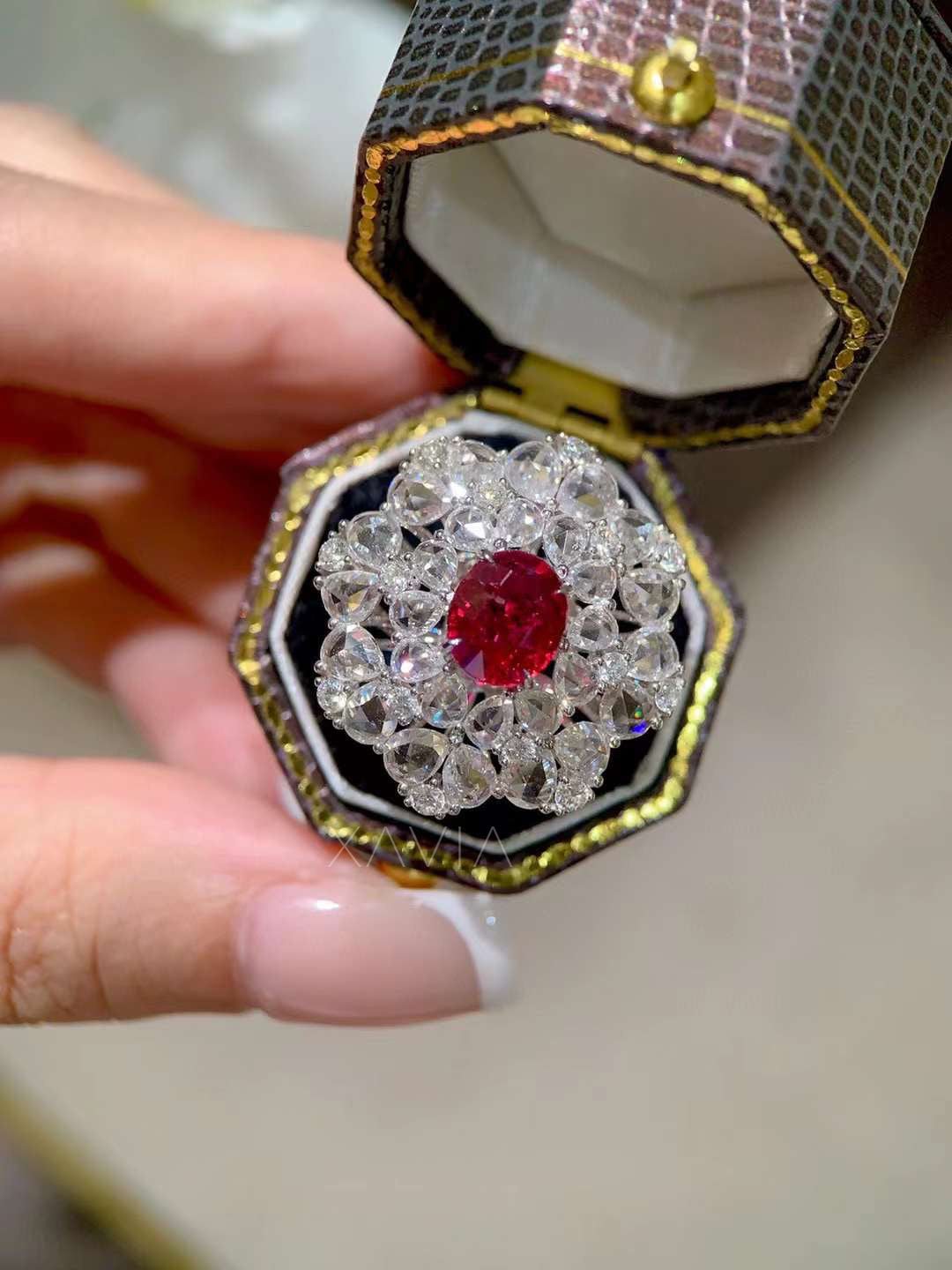 Close view of ruby center halo cocktail ring with layered round diamonds forming a floral bloom cluster halo design in luxury fine jewelry style
