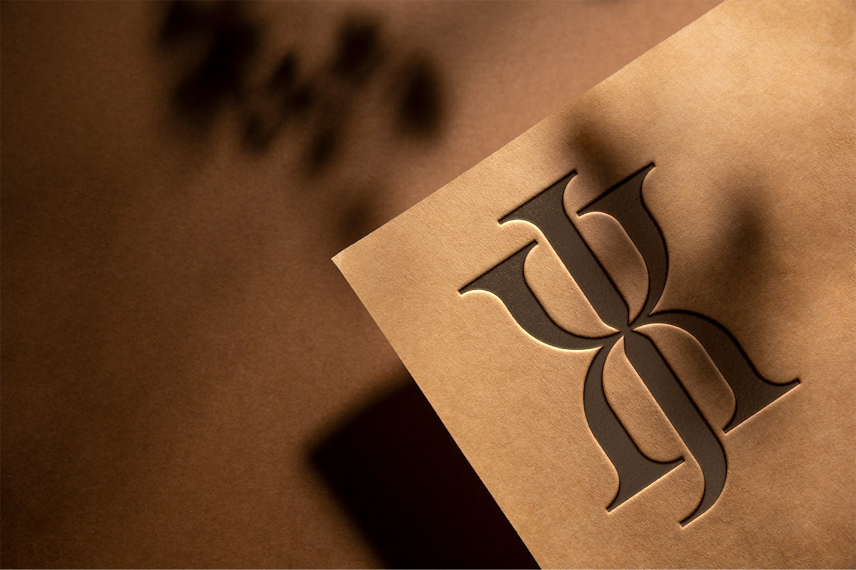 Brown paper with a embossed logo on a brown background - Xavia Jewels