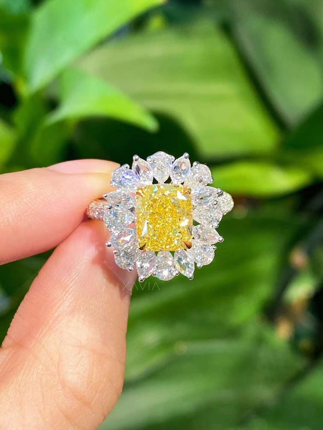 Yellow cushion cut lab diamond engagement ring with floral marquise halo worn on hand, showcasing luxury sparkle and elegant halo design