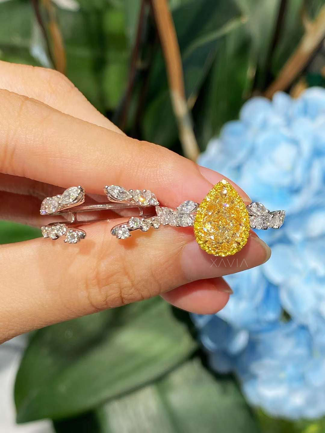 top view of vivid yellow pear diamond halo ring with platinum setting and leaf-inspired white marquise diamond band