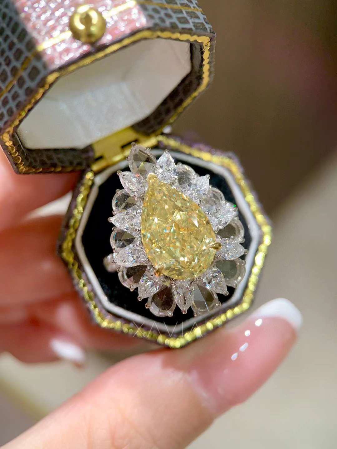 statement fancy yellow pear cut diamond cocktail ring with marquise diamond halo cluster worn on model’s hand