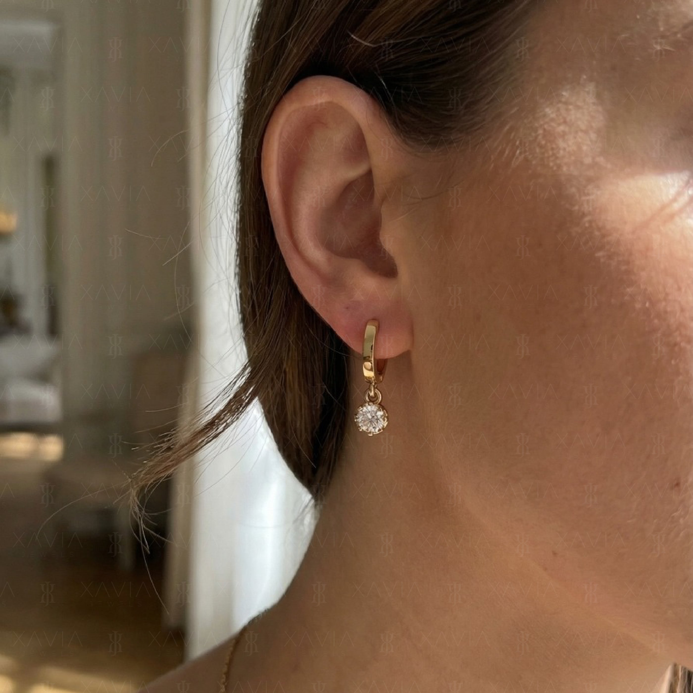 Model wearing polished yellow gold lab diamond drop huggie earrings with round brilliant solitaire dangles designed for modern everyday luxury styling