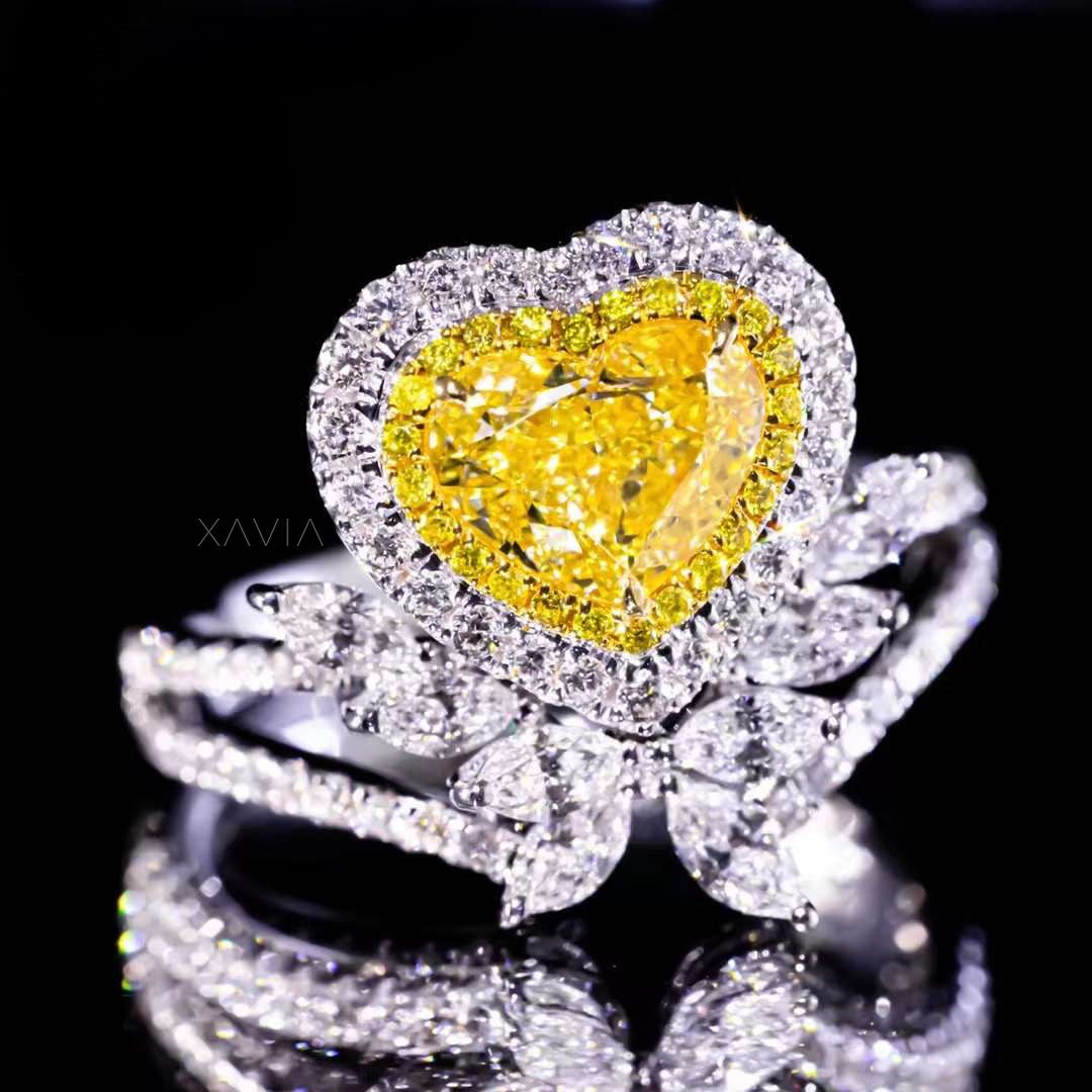 fancy yellow heart diamond ring with floral marquise diamonds and halo design worn elegantly on model’s hand